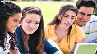 Un grupo de estudiantes consulta un ordenador.